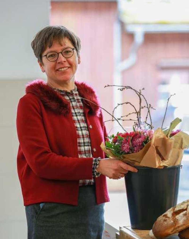 Elke Bollmann, die übergreifende Leitung der Diakonie Erlangen erhält einen Blumenstock.