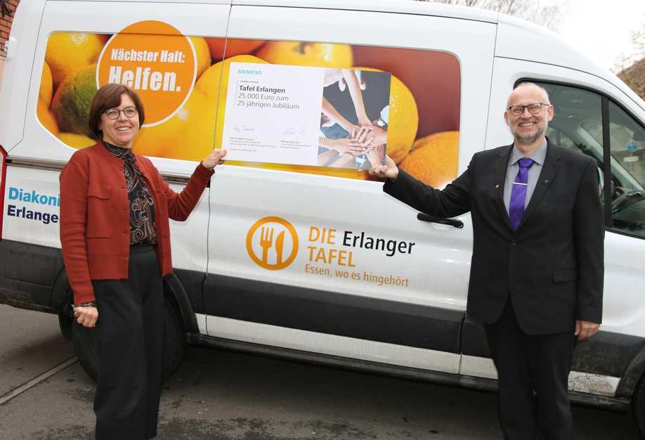 Elke Bollmann (Leiterin der Tafel Erlangen) und Matthias Ewelt (Vorstandssprecher der Diakonie Erlangen) freuen sich über den Scheck der Siemens AG